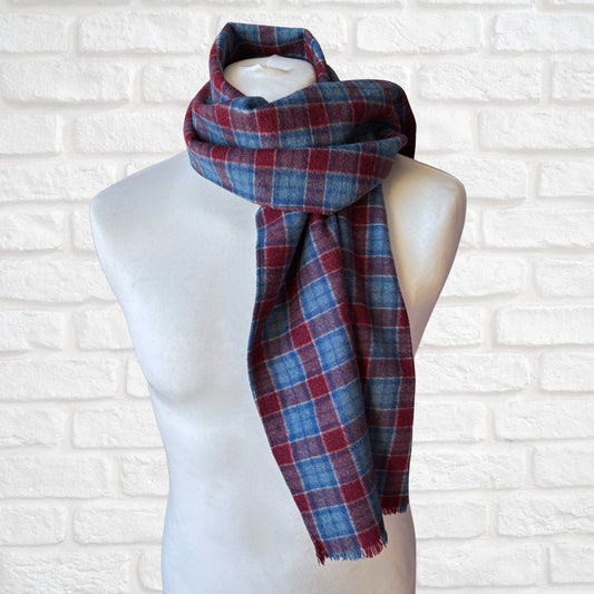Plaid scarf on a mannequin against a white brick wall