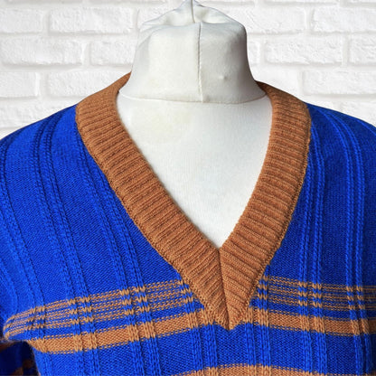 Blue and brown striped sweater on a mannequin against a white brick wall.