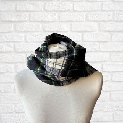 Plaid scarf on a mannequin against a white brick wall background