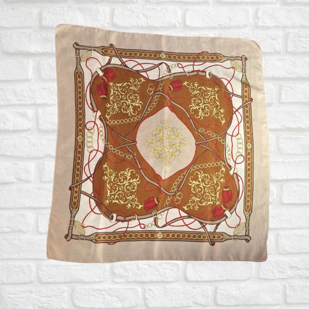 Decorative pillow with intricate gold and red design on a beige background