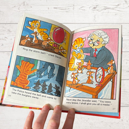 Open children's book with illustrated pages on a wooden surface