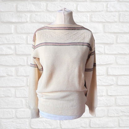 A cream-colored knit sweater with thin horizontal stripes in green and brown , displayed on a mannequin torso against a white brick wall background.