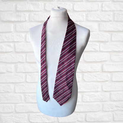 Striped scarf on a mannequin against a white brick wall background