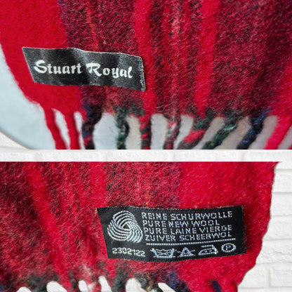 Close-up of a red plaid fabric with 'Stuart Royal' label and additional text on a white background.