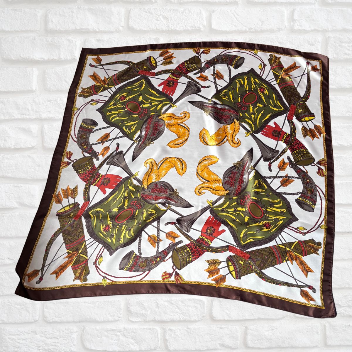 Decorative scarf with armoury pattern on a white brick wall background