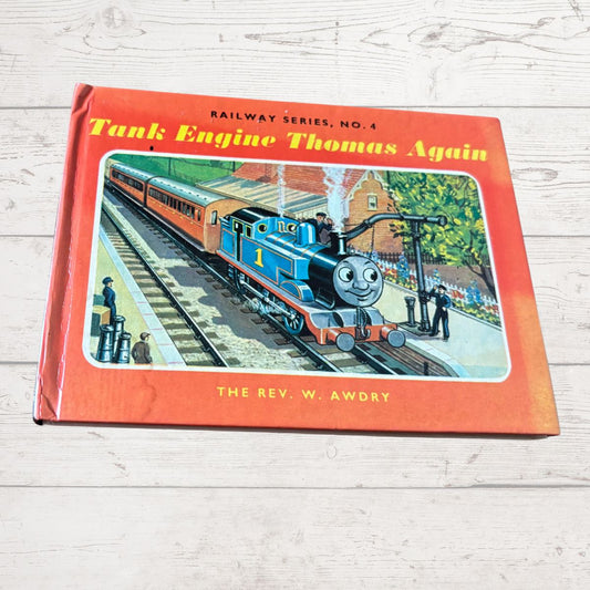 Book titled 'Tank Engine Thomas Again' by W. Awdry on a wooden surface