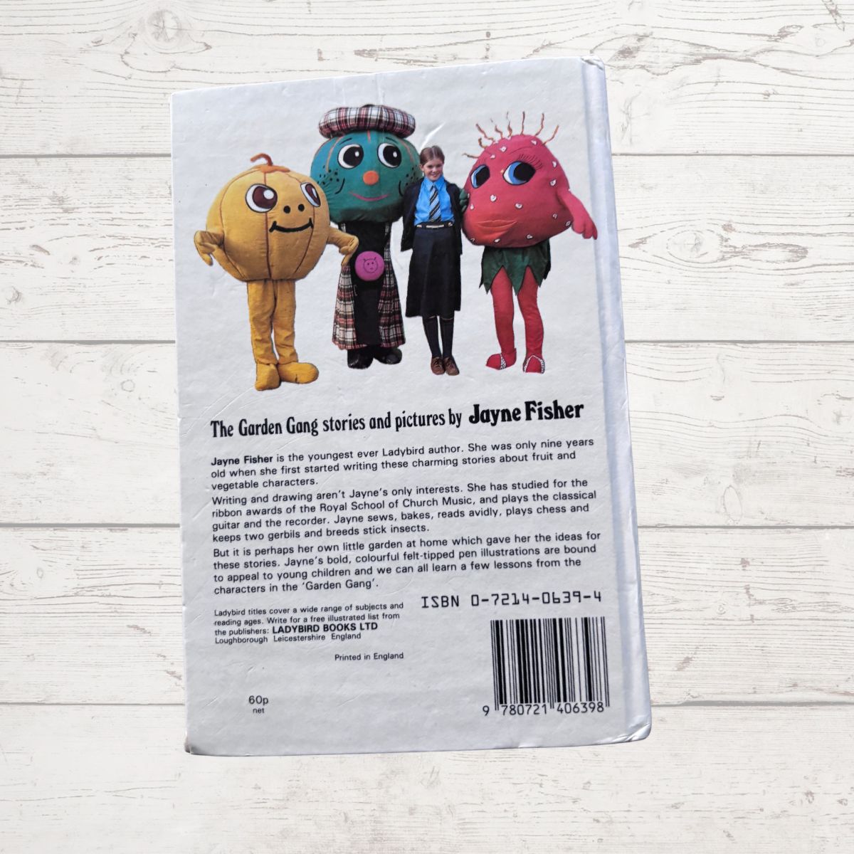 Back cover of a book with colorful characters and text on a light wooden surface