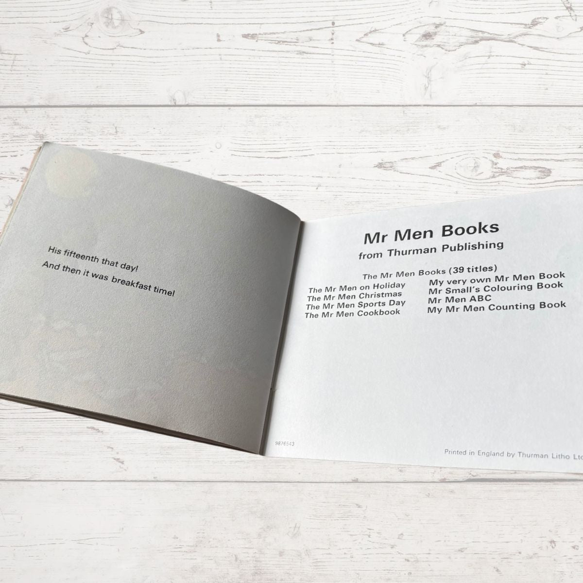 Open book on a wooden surface with text about Mr Men books from Thurman Publishing.