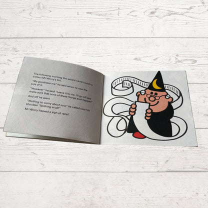 Open book with a cartoon character on a wooden surface
