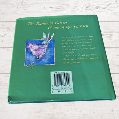 Back cover of a book titled 'The Rainbow Fairies & the Magic Garden' with a fairy illustration on a green background.