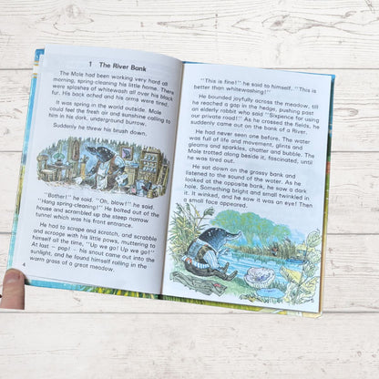 Open book with illustrations and text on a wooden surface