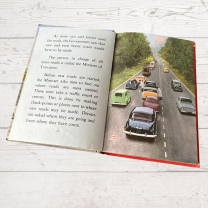 Open book with a road scene and text on a wooden surface