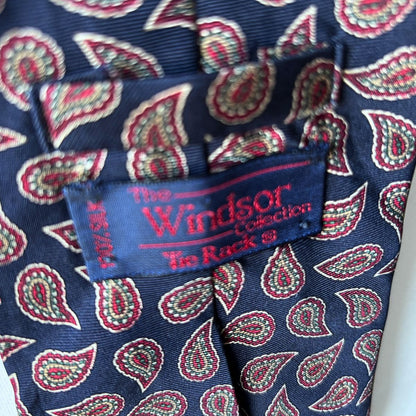 Navy and Red Paisley Silk Vintage Tie On a white brick background - close up of label 