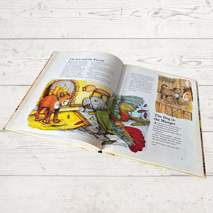 Open book with illustrations of a parrot and a dog on a wooden surface