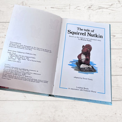 Open book with a cover featuring a squirrel and text about 'The Tale of Squirrel Nutkin'.