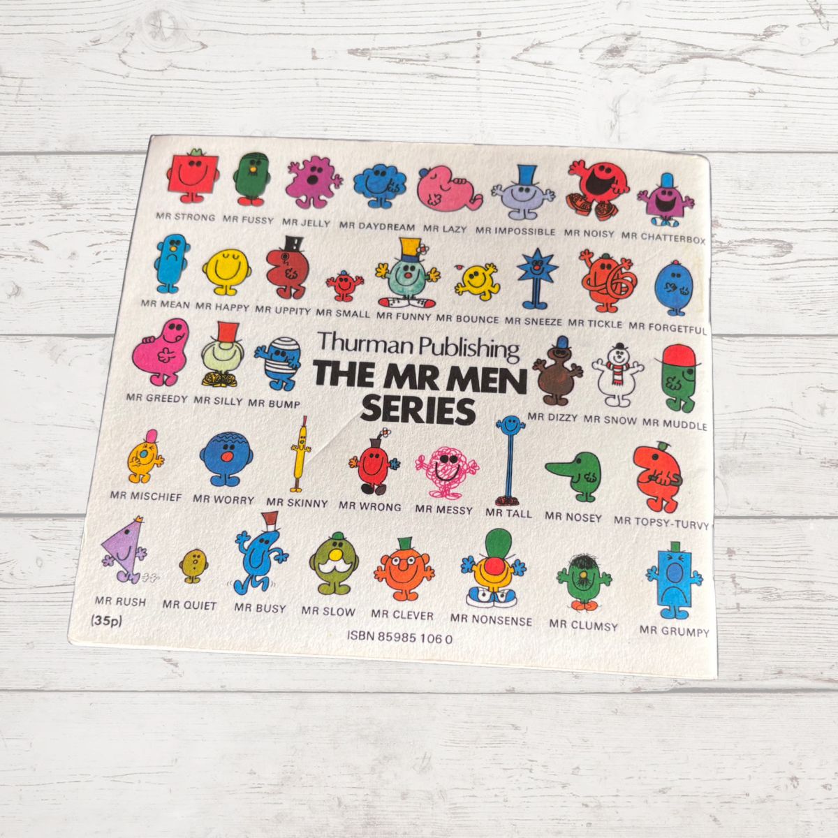 Poster of Mr. Men characters from Thuman Publishing on a wooden surface