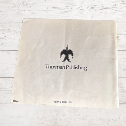 Beige paper with 'Thurman Publishing' logo on a light wooden surface