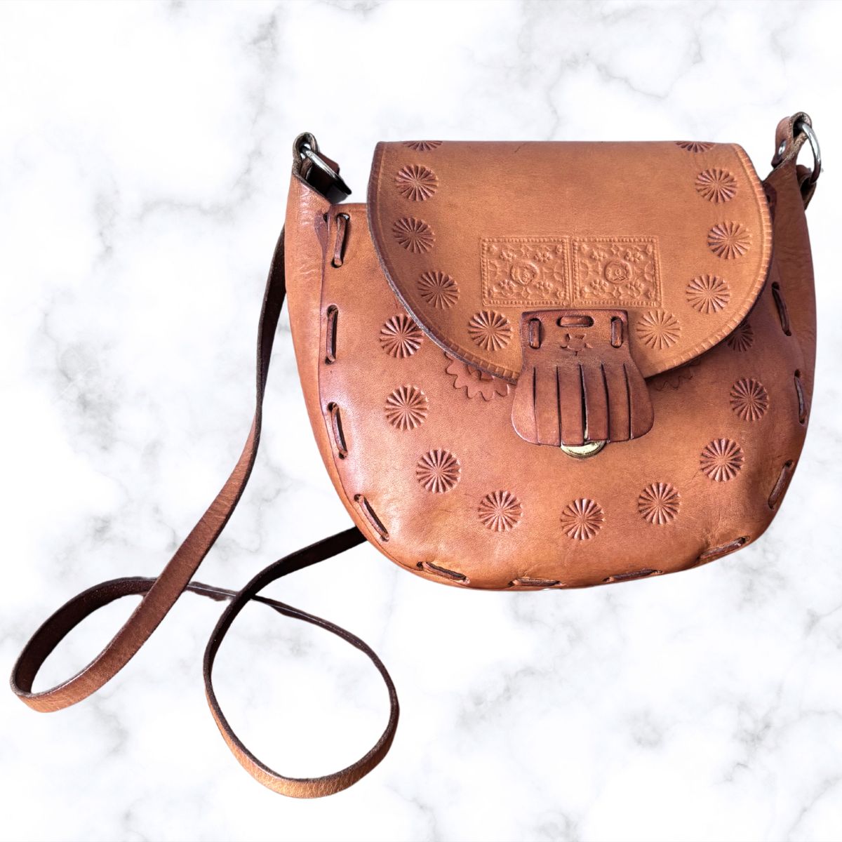 Tooled leather shoulder bag on a white background 