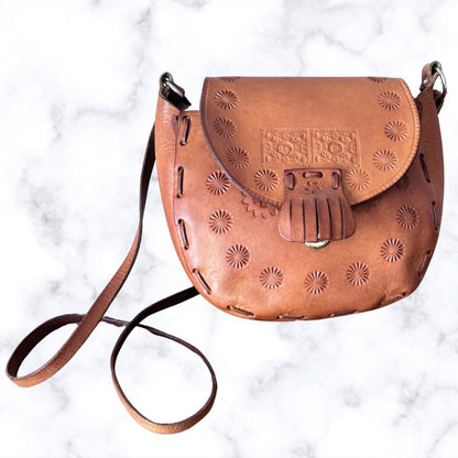 Tooled leather shoulder bag on a white background 