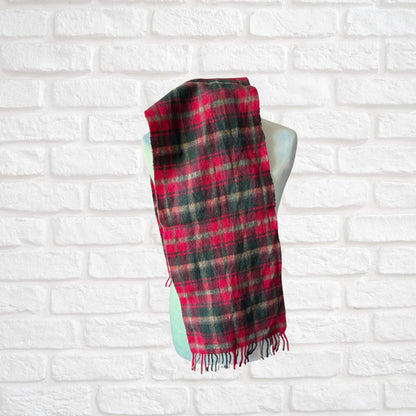 Plaid scarf on a mannequin against a white brick wall background
