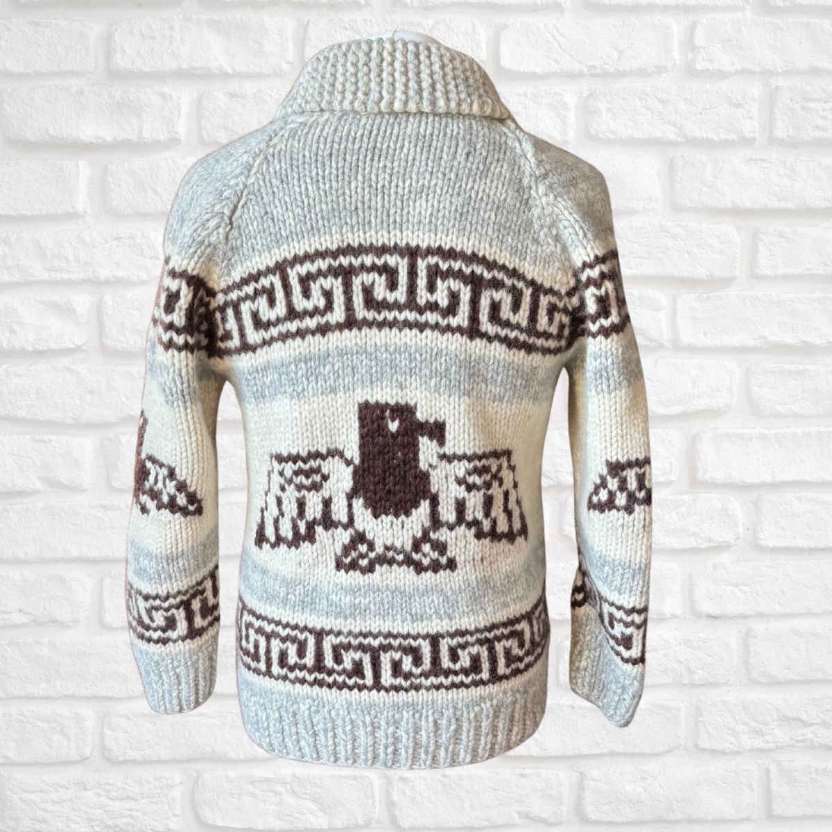 Knitted sweater with a pattern against a white brick wall