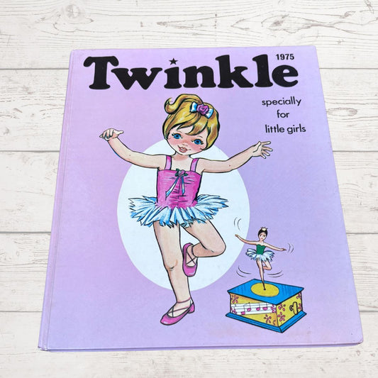 A vintage 1975 children's book titled 'Twinkle' with the subtitle 'specially for little girls,' featuring an illustration of a ballerina on a light purple cover, photographed on a whitewashed wood surface.