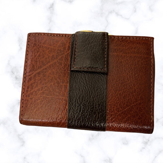 Brown leather wallet with a textured finish on a white marble background