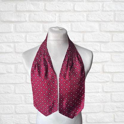 Red patterned cravat on a mannequin against a white brick wall background