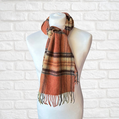 Plaid scarf on a mannequin against a white brick wall