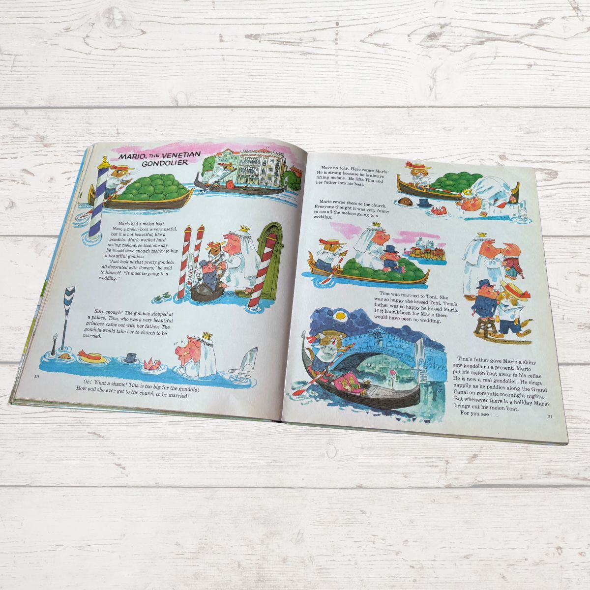 Open book with colorful illustrations on a wooden surface