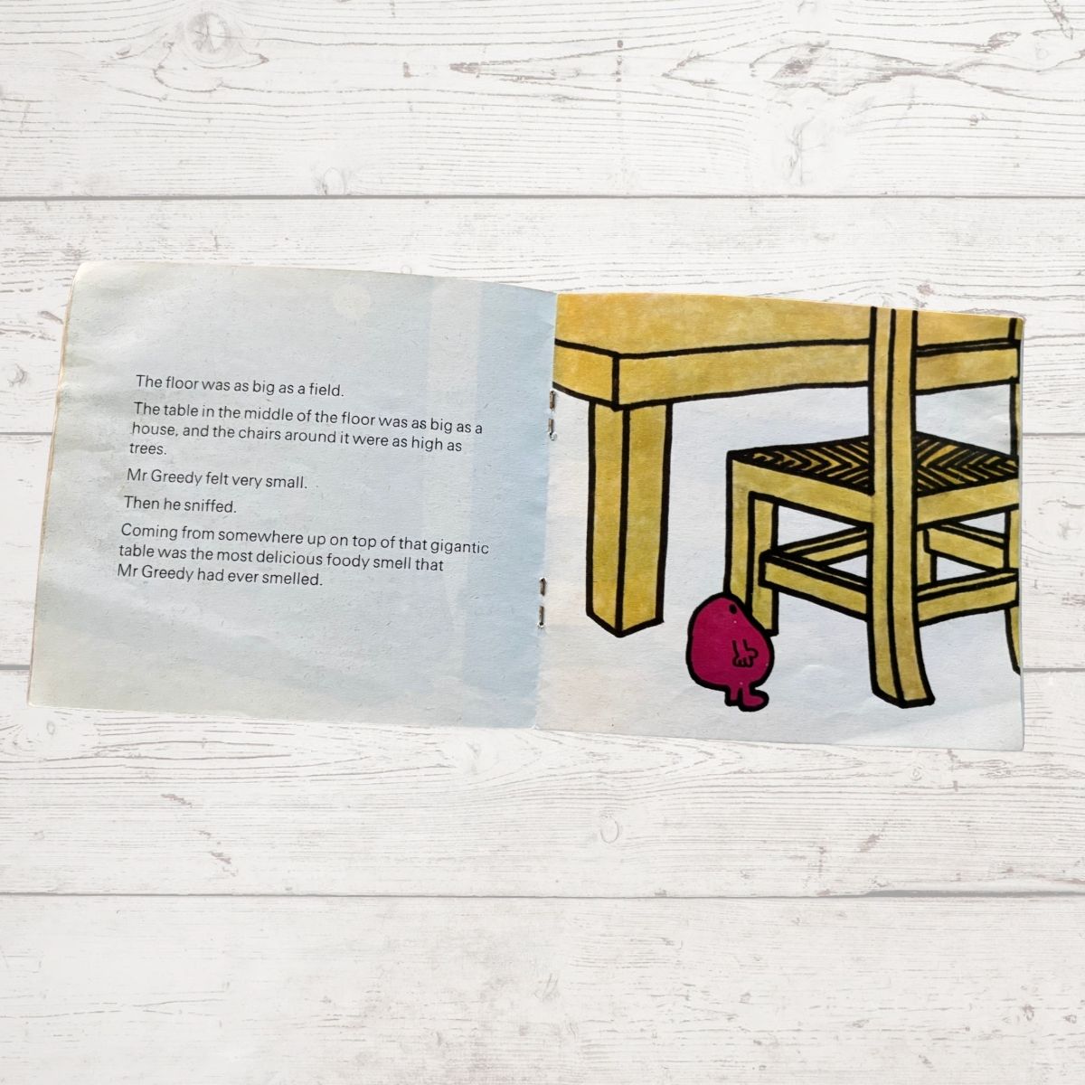 Mr Greedy next to a huge  table and chair 