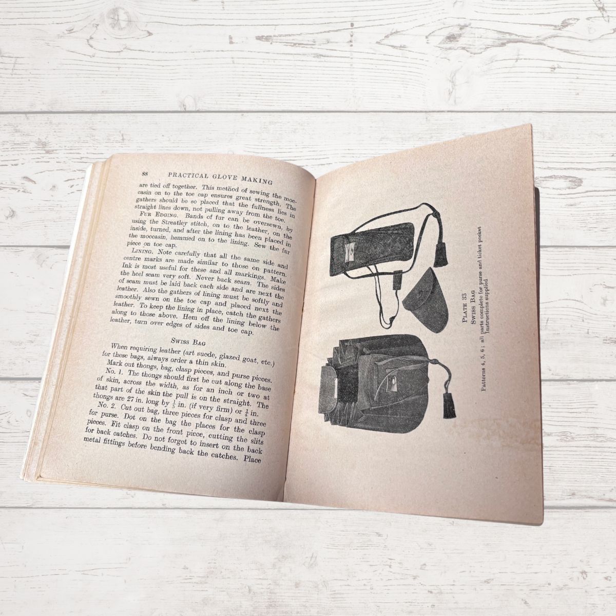 Open book with text and illustrations on a wooden surface