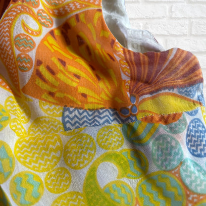 Colorful fabric with geometric patterns on a white brick wall background