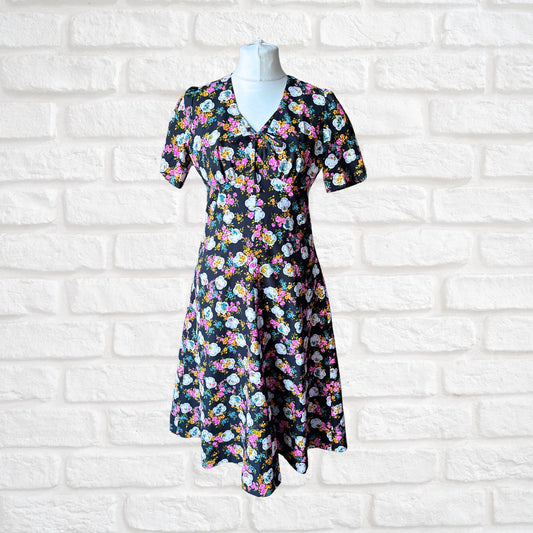 70s black and bright floral print short sleeved vintage tea dress. Approx UK size 12-14