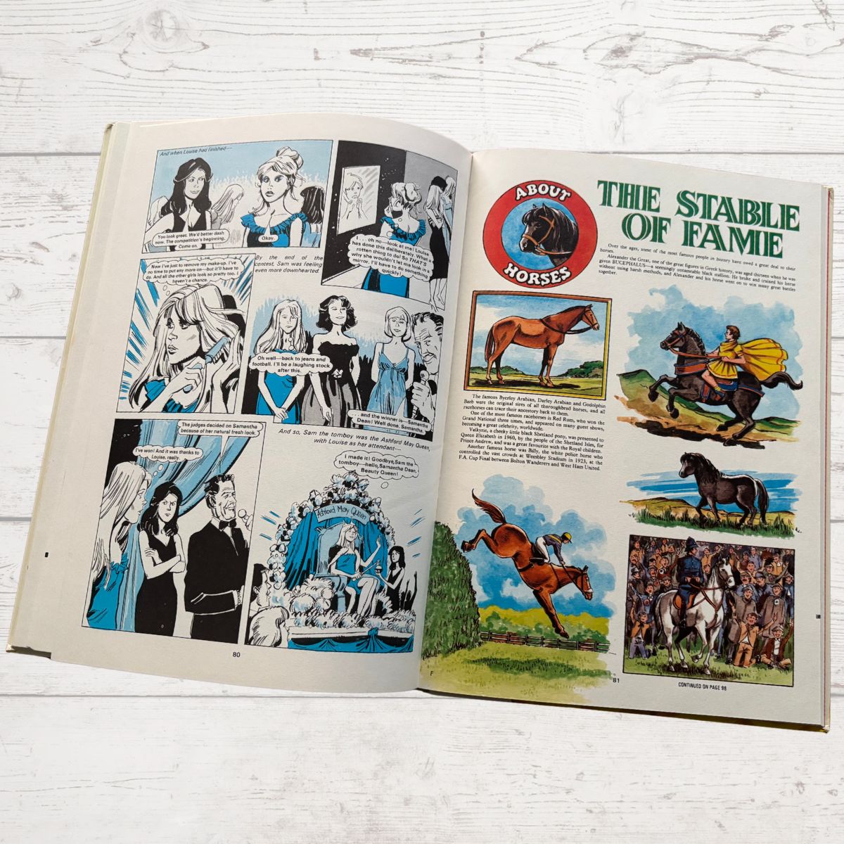 Open book with comic strip and illustrations of horses on a wooden surface