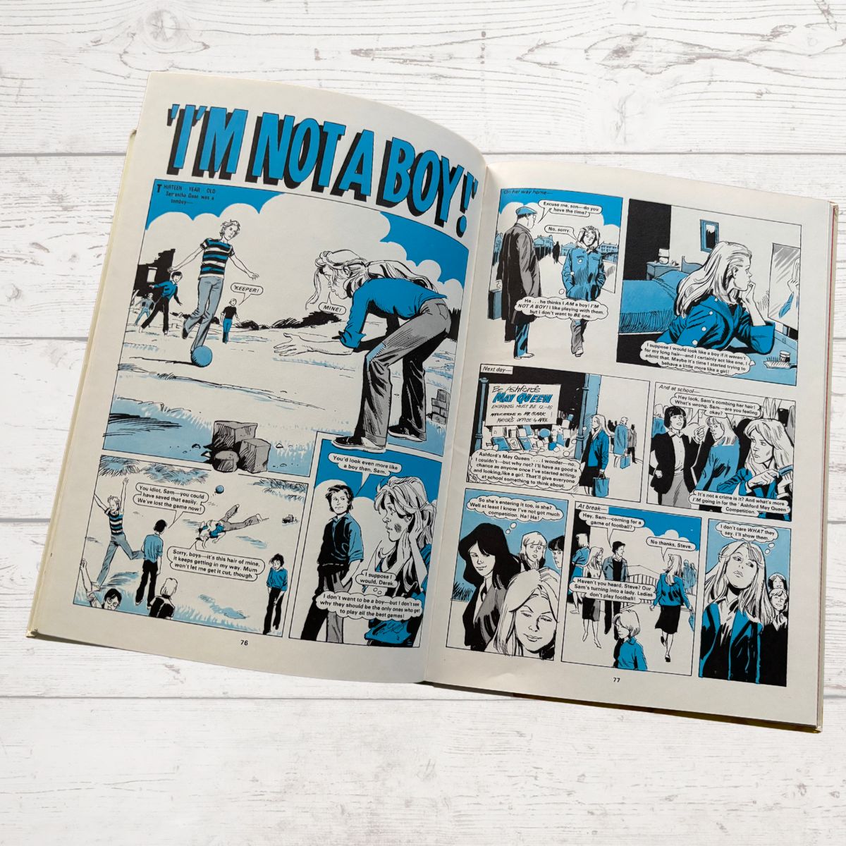 Open comic book with panels on a wooden surface