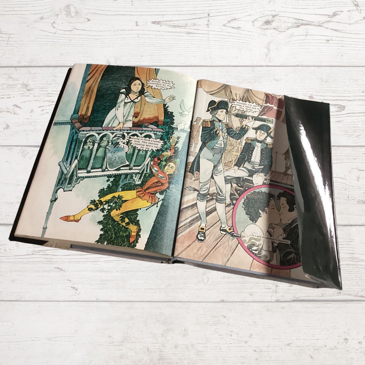 Open book with vintage-style illustrations on a light wooden surface