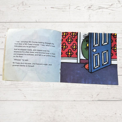 Open book with colorful illustration and text on a wooden surface