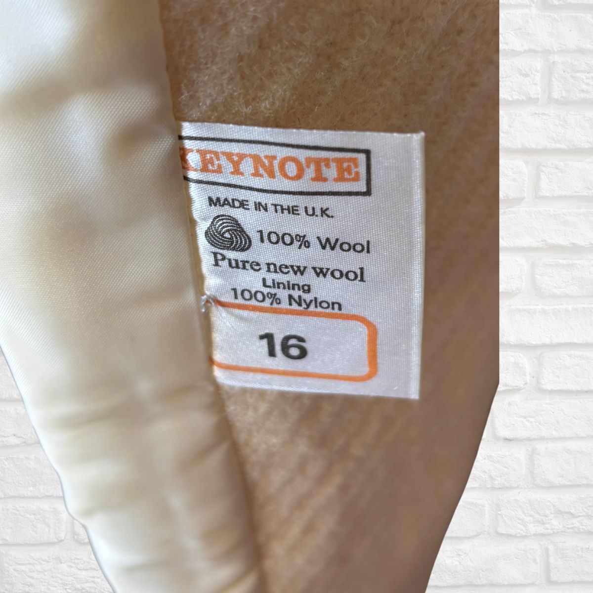 Label on a garment indicating 'Keynote' brand, 100% wool, pure new wool lining, 100% nylon, size 16, made in the U.K.