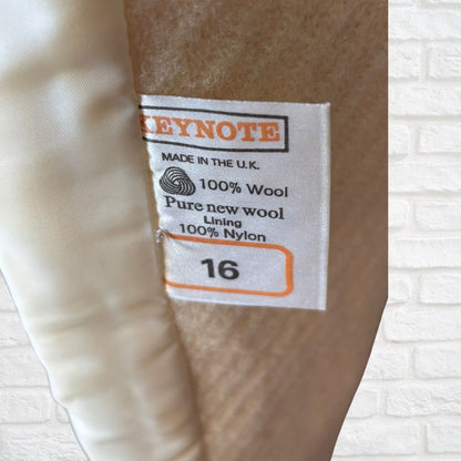 Label on a garment indicating 'Keynote' brand, 100% wool, pure new wool lining, 100% nylon, size 16, made in the U.K.