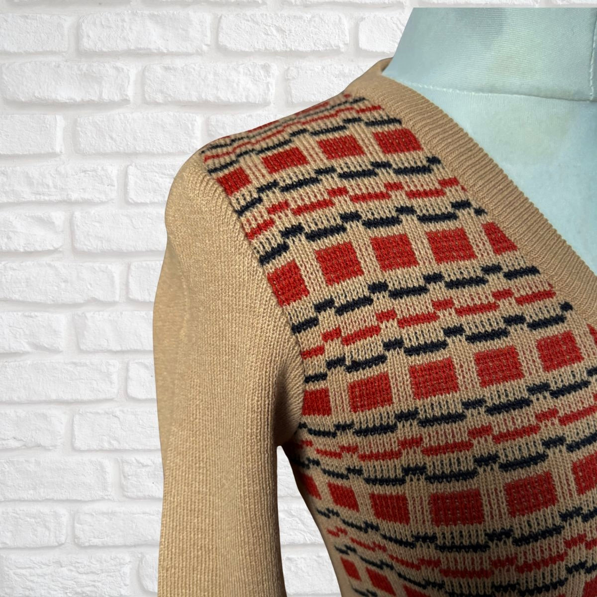 Brick red, dark tan and black 70s patterned sweater close up 