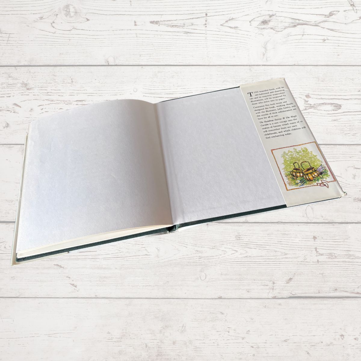 Open book with a colored illustration on a white wooden surface