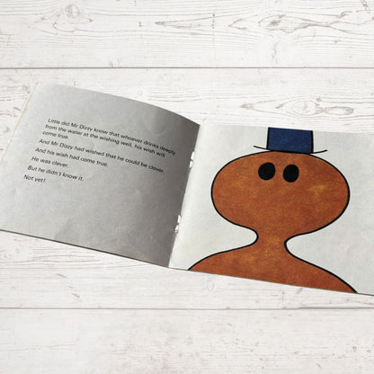 Open book with a cartoon character on a wooden surface