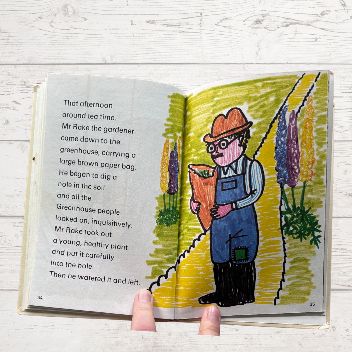 Open book with a colorful illustration of a gardener and text on a wooden surface