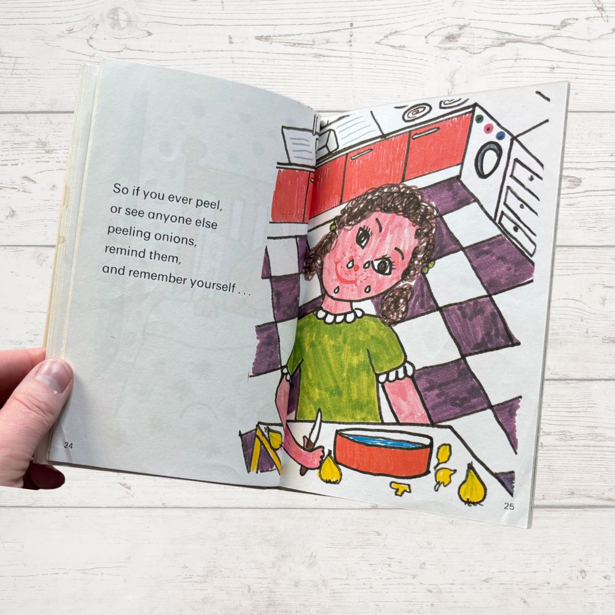 Open book with a colorful illustration of a person peeling onions in a kitchen.