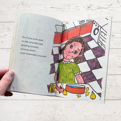 Open book with a colorful illustration of a person peeling onions in a kitchen.