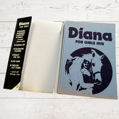 Open book titled 'Diana for Girls 1978' with a horse illustration on a wooden surface.