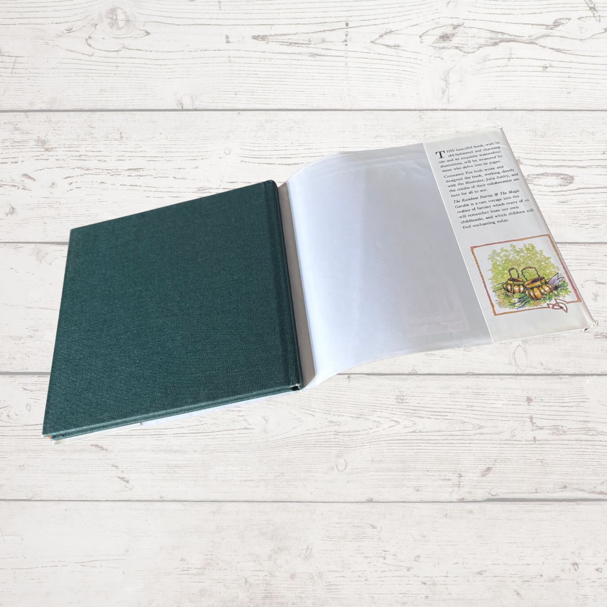 Open book with a green cover on a light wooden surface