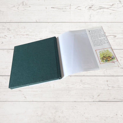 Open book with a green cover on a light wooden surface