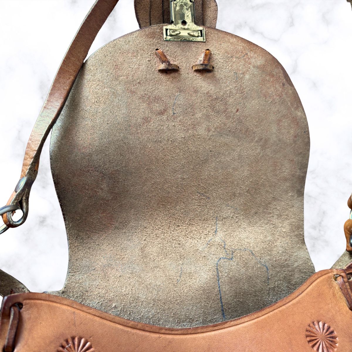 Tooled leather shoulder bag open on a white background 
